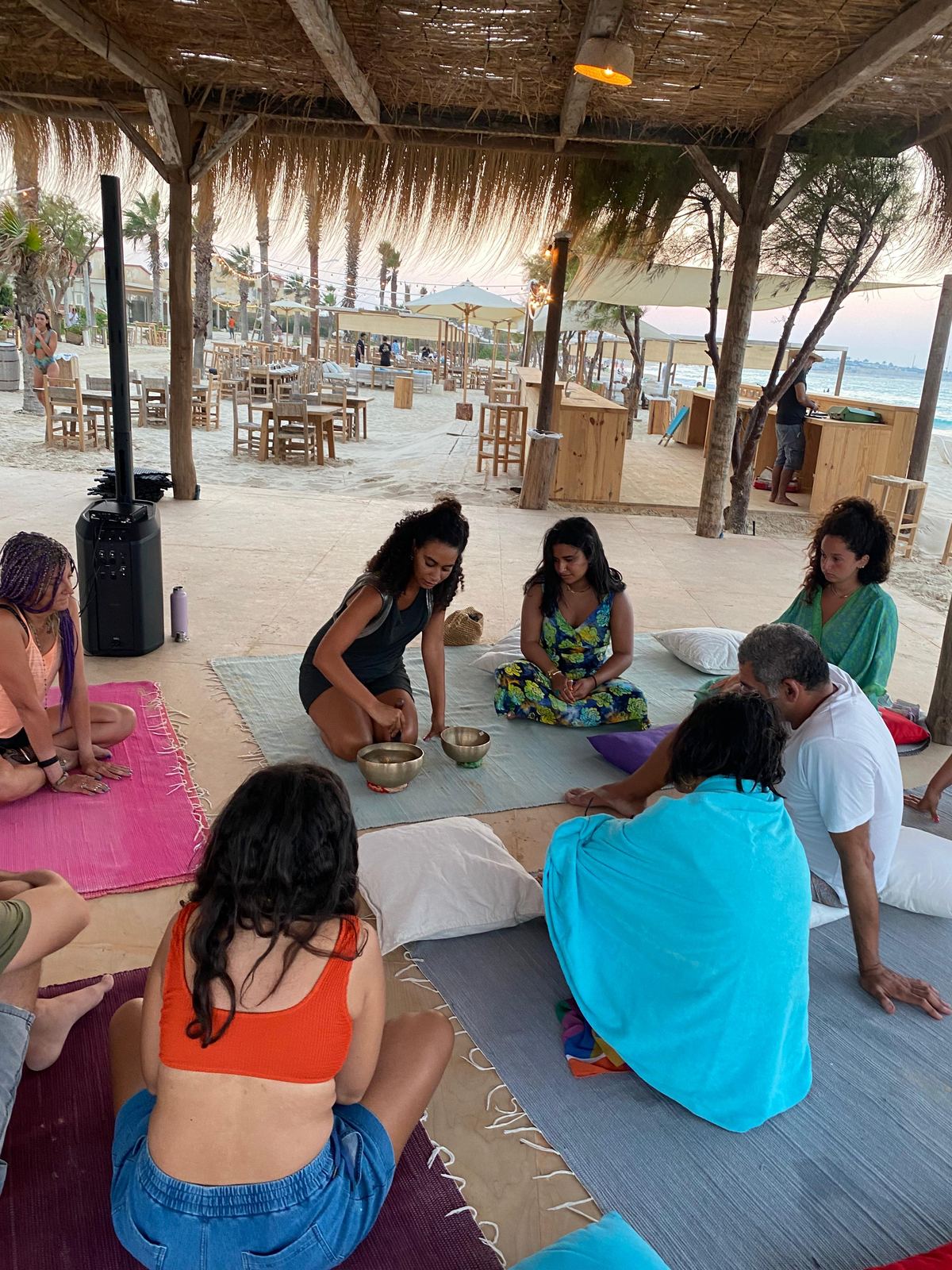 Group gathered in a circle on the Mediterranean beach