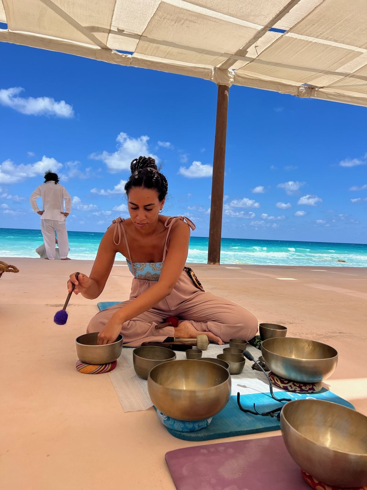 Hana playing singing bowls on the beach at sunset